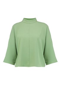 Blusa verde, ampia e morbida, realizzata in tessuto liscio. Caratterizzata da un colletto alto e rotondo e maniche larghe, con un design semplice e pulito.