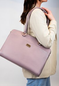 Roze leren handtas met een gladde textuur, ritssluiting en gouden hardware-accenten. Wordt geleverd met lange schouderbanden voor gemakkelijk dragen.