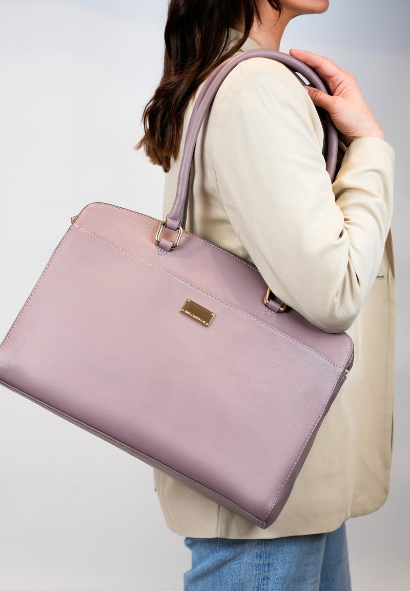 Roze leren handtas met een gladde textuur, ritssluiting en gouden hardware-accenten. Wordt geleverd met lange schouderbanden voor gemakkelijk dragen.