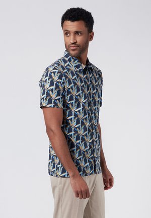 Camisa de manga corta en azul marino oscuro con un patrón floral en azul y dorado. Presenta un cuello abotonado y un corte relajado. Textura de tela suave.