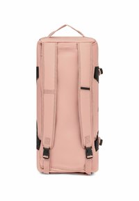 Sac de sport rose avec des sangles noires réglables, base plate et poignée supérieure. Tissu lisse, forme rectangulaire et design minimaliste.