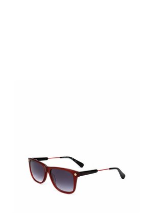 Occhiali da sole rossi e neri con lenti quadrate sfumate e sottili aste in metallo rosso su sfondo bianco.