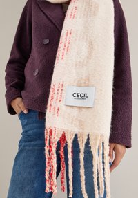 Uldblandingshalsscrf i creme med røde accenter, med frynsede kanter og et mærke, der læser "CECIL ACCESSORIES." Tekstureret og blød.