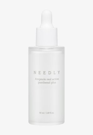 Bouteille en verre clair avec un bouchon compte-gouttes blanc, étiquetée "NEEDLY Ampoule real active panthenol plus," volume de 50 ml, texture lisse.