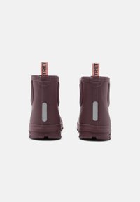 Lila gummistövlar till vristerna med en texturerad yta, dragöglor och reflektoraccenter på baksidan för ökad synlighet.