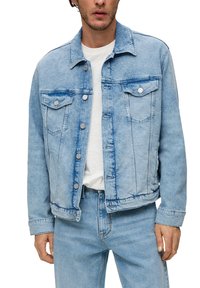 Jasnoniebieska kurtka dżinsowa z kołnierzem, dwoma kieszeniami na piersiach i srebrnymi zapięciami na guziki. Posiada wyblakłą teksturę oraz widoczne detale przeszyć.
