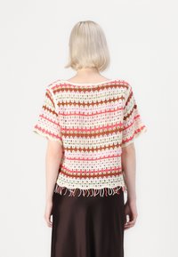 Häkeloberteil mit pinken, weißen und braunen Streifen, kurzen Ärmeln und fransenbesäumtem Saum. Hergestellt aus strukturiertem Garn, zeigt ein offenes Strickdesign.