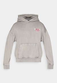 Γκρι φαρδιά μπλούζα με κουκούλα από βαμβακερό μείγμα, διαθέτει μπροστινή τσέπη και μικρό λογότυπο με φτερά στην αριστερή πλευρά του στήθους.