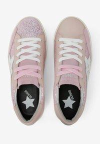 Sneakers rosa con punta glitterata, lacci bianchi e logo a forma di stella. Realizzate con materiali lisci e testurizzati, caratteristiche di un design basso.