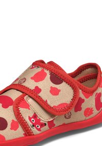 Scarpa beige per bambini con rifiniture rosse, motivi di animali e forme rosse, e una faccia di volpe rossa sulla fascia con chiusura a strappo.