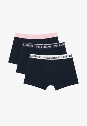 Trzy czarne bokserki ułożone w stos, każda z innym kolorem elastycznego paska w różowym, ciemnoszarym i białym, wszystkie marki "PULL&BEAR."