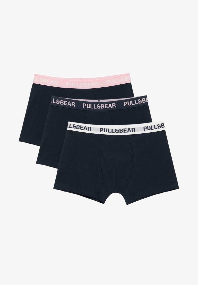 Trois boxers noirs empilés, chacun avec une ceinture élastique de couleur différente en rose, gris foncé et blanc, tous de la marque "PULL&BEAR."
