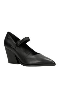 Scarpa nera in pelle con tacco alto, punta appuntita e cinturino regolabile. Caratterizzata da un tacco a cuneo testurizzato e una fodera interna liscia.