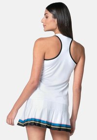 Vestido deportivo blanco con parte superior ajustada y falda plizada. Presenta ribetes negros y franjas horizontales de colores en el dobladillo. Textura suave.