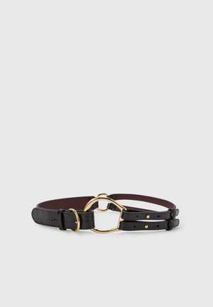 Ceinture en cuir noir à texture croco, avec boucle reliée dorée et double design de sangle sur un fond gris clair uni.