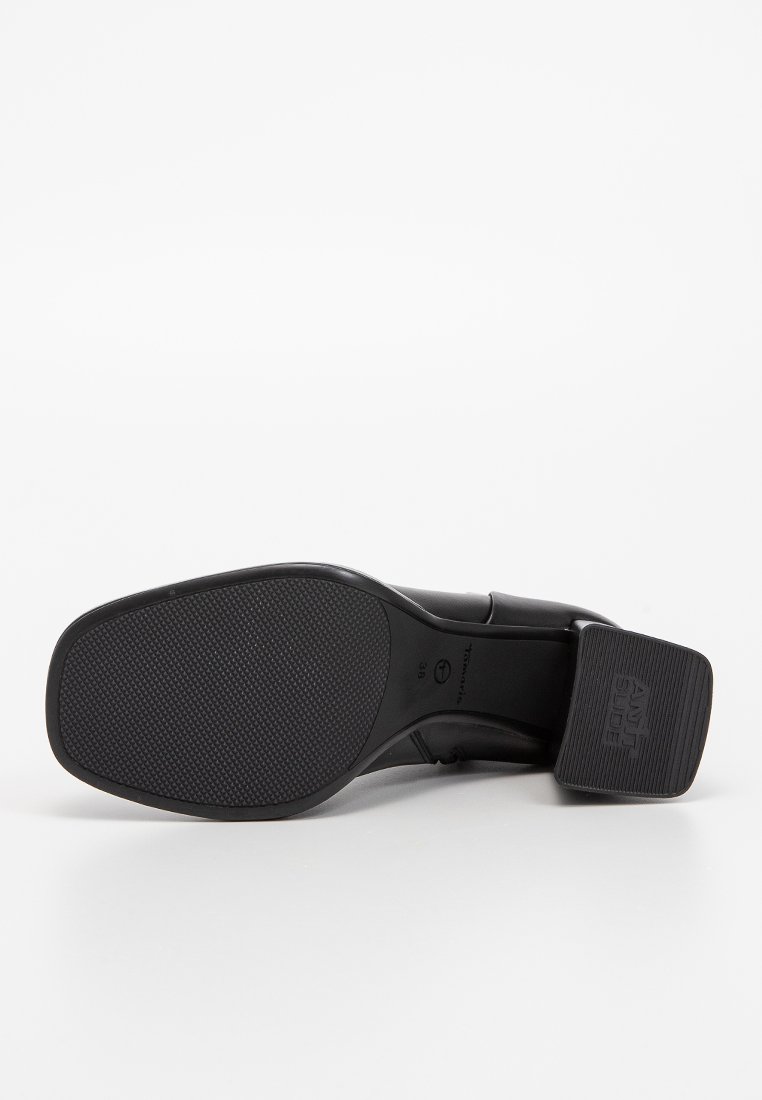 Zwarte leren schoenzool met een gestructureerd oppervlak en een lichte hak. Kenmerkt zich door branding en een gladde, ronde randontwerp.