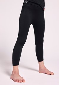 Leggings sportivi neri con un motivo testurizzato, design aderente e polsini alla caviglia. Presentano un logo sulla vita e un tessuto aderente e liscio.