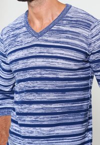 Blå och ljusgrå randig långärmad skjorta med v-ringning, gjord av mjukt material, med ett texturerat stickat mönster och ribbad mudd.