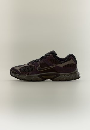 Черна и тъмнокафява маратонка Nike с мрежести панели и дебела гумена подметка, показана в страничен изглед на неутрален фон.
