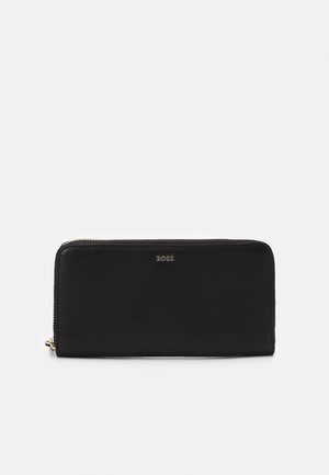 Zwarte leren portemonnee met een gestructureerde afwerking, ritsluiting en reliëflogo aan de voorkant. Compact rechthoekig model met gouden hardware.