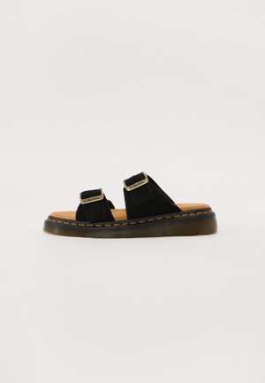 Sort åben-tå sandal med to justerbare remme med metalspænder og en tyk sål med synlige gule syninger.