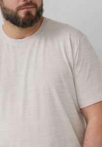 Lichtgrijze t-shirt met korte mouwen, gemaakt van zacht, gestructureerd stof met een subtiel gemêleerd patroon, voorzien van een ronde hals.
