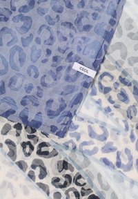 Foulards légers avec des motifs léopard bleus et noirs, dont un avec une étiquette de tissu "CECIL" cousue sur le bord.