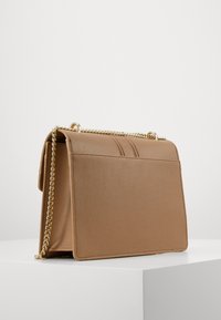 Hnědá strukturovaná kabelka s texturovaným povrchem, zlatým řetízkem a klopovým uzávěrem. Vyznačuje se viditelným šitím a elegantním designem.