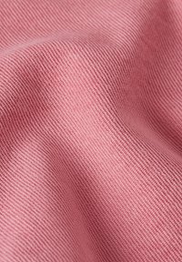 Texturerad tyg i mjuk rosa nyans, med ett fint diagonalt randmönster, som har en slät och något elastisk yta.