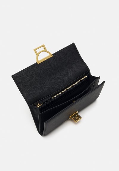 Bolso de mano de cuero negro con un acabado texturizado. Cuenta con un cierre metálico dorado y una cremallera, con dos compartimentos internos.