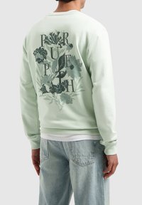 Mintgroene sweatshirt met een bloemen grafisch ontwerp op de achterkant met opdruk, geribbelde manchetten en zoom. Lichte stof met een soepele textuur.
