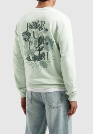 Mintgrüner Sweatshirt mit einem floralen Grafikdesign auf der Rückseite, ergänzt durch Schriftzug, gerippte Abschlüsse und Saum. Leichter Stoff mit glatter Textur.