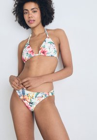 Gėlių bikini komplektas, turintis trikampį viršų su reguliuojamomis petnešomis ir žemai stovinčią apačią su šoniniu raišteliu. Ryškios tropinės spalvos ir raštai.
