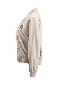 Beige Bomberjacke mit einem Reißverschluss auf der Vorderseite, geripptem Kragen und Bündchen sowie einem kleinen schwarzen Logo auf der linken Schulter. Glatte, leichte Stoffqualität.