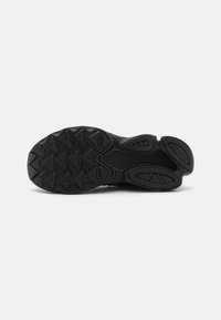 Black athletic shoe sole with a textured, patterned grip. Features prominent traction lugs and a smooth central section for stability.