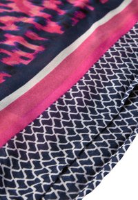 Sciarpa multicolore con motivi rosa e blu navale, con un bordo geometrico bianco. Realizzata in tessuto morbido, con una texture liscia.