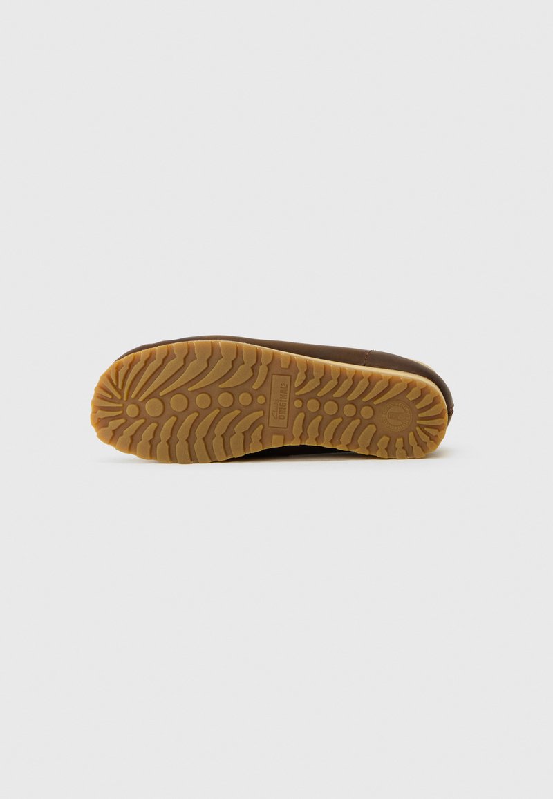 Chaussure imperméable marron avec une semelle en caoutchouc texturée présentant un motif de semelle pour une meilleure adhérence. La partie supérieure a une finition lisse et une forme légèrement incurvée.