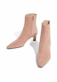 Botas de ante rosa hasta el tobillo con punta afilada y un bajo tacón cuadrado. Cuenta con un zipper lateral y un forro interior suave.