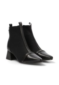 Botas negras hasta el tobillo con punta y talón de cuero liso, parte superior de tela elástica y un tacón cuadrado con una banda de acento texturizada.