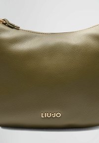 Olijfgroene leren tas met een structuurafwerking, voorzien van een rits in goudkleur en het LIU-JO-logo. Strak, gebogen ontwerp dat zacht aanvoelt.