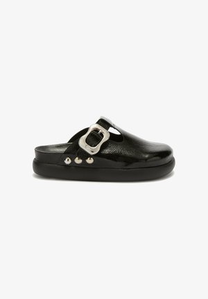 Black leather slip-on mules with a rounded toe, featuring a silver buckle, three decorative studs, and a textured finish. Black sole.