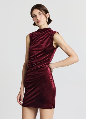 Burgunderrotes Samtkleid mit enger Passform, hohem Ausschnitt und kurzen Ärmeln. Verziert mit drapierten Details entlang des Körpers für mehr Struktur.