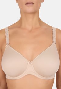 Beige bh med glat stof, blondestropper og en sløjfe i midten. Har bøjler og delikat perlekant langs kanterne.