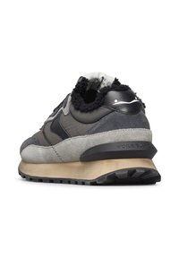 Scarpa sportiva grigia e nera in materiale scamosciato e pelle, con accenti testurizzati e suola in gomma. Presenta un tacco definito e un logo.