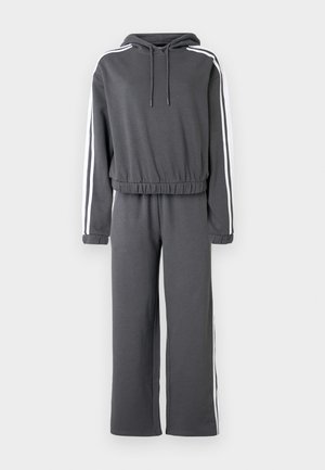 Hall hallituskomplekt, millel on kapuuts, elastne vöökoht ja valged küljeribad. Valmistatud pehmest kangast, lõdva sobivusega ja pikkade varrukatega.