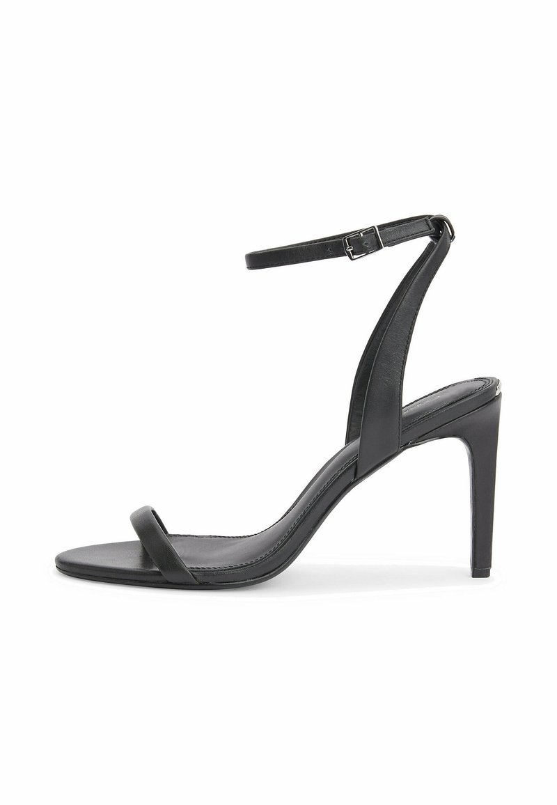 Sandale à talon haut en cuir noir avec une fine bride sur les orteils et une bride ajustable à la cheville. Texture lisse et design élégant.