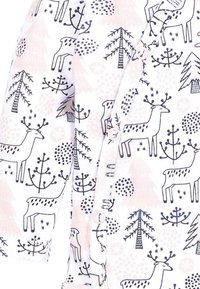 Weißer Stoff-Overall mit schwarzen Hirsch-, Baum- und Punkte-Mustern, verziert mit pastellrosa Akzenten und einem vorderen Druckknopfverschluss.