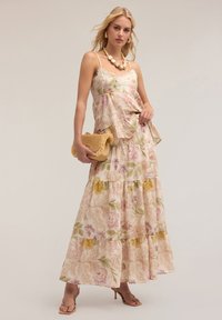 Rochie maxi florală cu design în straturi, având culori pastelate de roz, galben și verde. Material texturat cu accente de dantelă și bretele subțiri.