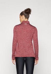 Rød meleret langærmet top med høj krave, tætsiddende design og logo detalje på bagsiden. Matchende med sorte leggings.