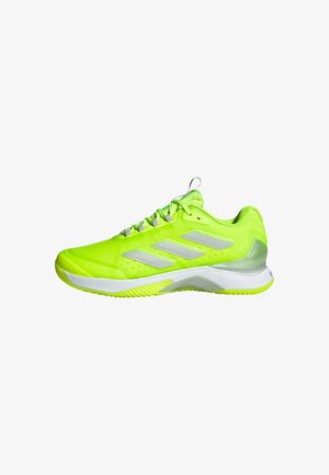 Sneaker sportiva verde neon con suola bianca, tre strisce grigie sul lato, design con lacci e colletto imbottito per supporto.